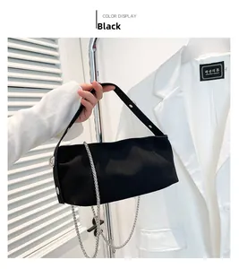 Detail view of black canvas underarm bag with silver chain and rivet decoration