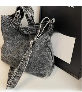 Macro shot showing the smooth adjustable long shoulder strap of a gray denim tote bag