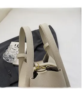 Detail of lychee pattern leather bucket bag with double handles and gold metal hardware