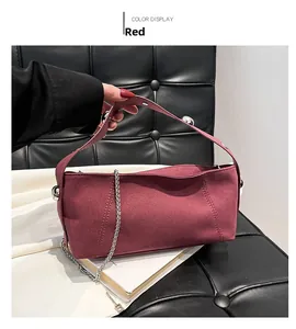Detail of burgundy suede shoulder bag with silver metallic beads and wide handle strap