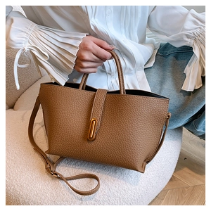 Brown lychee leather tote bag featuring gold hardware lock and detachable shoulder strap