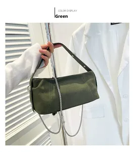 Detail of dark green velvet shoulder bag with silver chain and metal studs handles