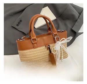 Detail of retro leather and straw bucket bag with lace bow and pearl charm ornament