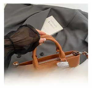 Detail of straw woven tote with brown leather trim, white lace bow, and pearl charm