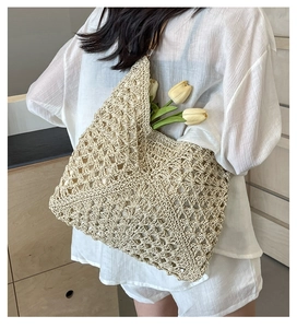 Détail du sac seau en paille beige tissé à la main avec motif ajouré complexe pour l'été