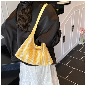 Détail du sac fourre-tout en maille rayée jaune et blanc avec large bandoulière en situation