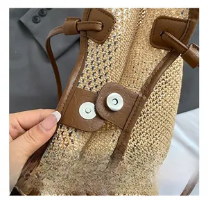 Detailed macro of the silver magnetic buckle on a woven straw tote with leather accents