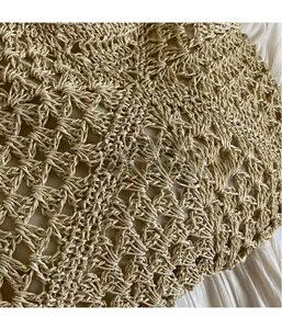 Macro detail of hand-woven hollow pattern on beige straw beach bag with fabric lining