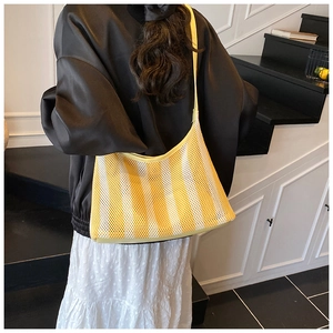 Gros plan sur le sac fourre-tout en mesh à rayures jaunes et blanches pour l'été