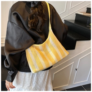 Détail du sac cabas en maille rayée jaune et blanc avec bandoulières en cuir