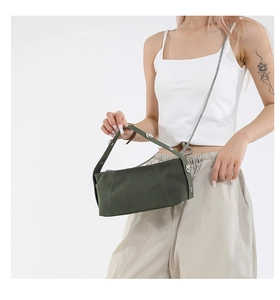 Detail of olive green canvas handbag with silver studs and metal chain strap