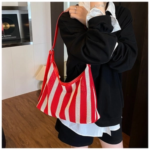 Détail du sac cabas en maille à rayures rouges et blanches avec bandoulière en cuir rouge