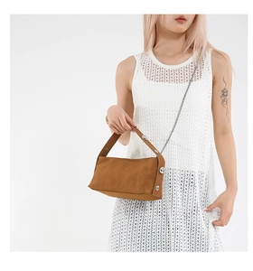 Detail of brown matte suede handbag with silver studs and elegant metal chain strap