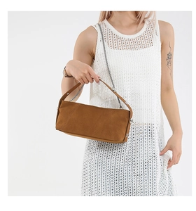 Detail of vintage brown suede hobo bag with silver chain and metal stud decorations
