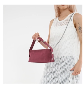 Close-up of burgundy underarm bag with wide handle and detachable fine metal chain