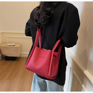 Close-up of deep red lychee texture bucket bag with HAMIROO logo carried by a model