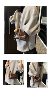 Detail of brown patent leather bag with Yimeiya logo embossing and plush keychain