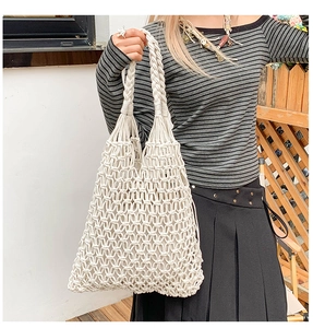 Detailed macro texture of white macramé woven handbag with intricate knot patterns