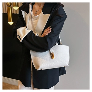 Detail of white lychee leather tote bag featuring elegant golden oval metal twist lock