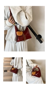 Detail of burgundy underarm bag with Yimeiya embossing and plush bear charm accent