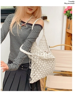 Close-up of a white hand-woven crochet hollow net tote bag with sturdy shoulder strap