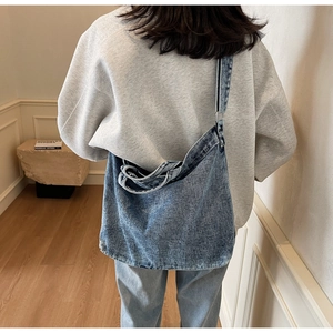 Detail of adjustable silver buckle on a vintage blue denim crossbody tote bag
