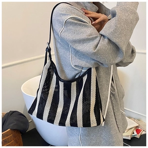 Nahaufnahme der schwarz-weiß gestreiften Mesh-Tasche über der Schulter für das Styling