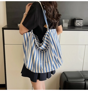 Detail view of large canvas tote bag with blue and white stripes for daily commuting