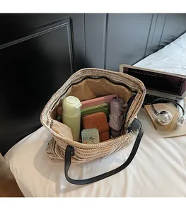 Spacious interior of striped woven tote bag holding a tablet, water bottle and umbrella