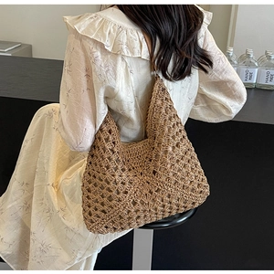 Detailed close-up of handmade hollow woven straw tote bag with intricate grid pattern