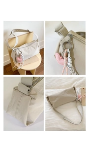 Detail of cream nylon shoulder bag featuring heart charm and woven rope accessories