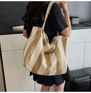 Close-up of the large khaki striped canvas tote bag showing texture and soft drape