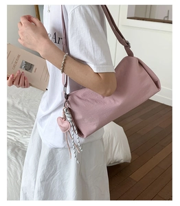 Détail du sac cylindre en nylon rose avec breloque cœur et tirettes de fermeture à nœud