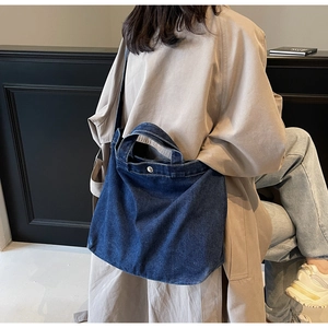 Macro detail of deep blue denim tote bag with metal button closure and durable canvas texture