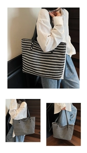 Detail showing the black and white striped straw tote bag with black leather shoulder straps