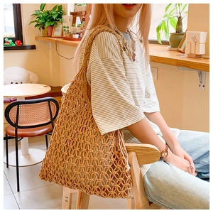 Close-up of handmade woven hollow shoulder bag in khaki cotton rope on a model