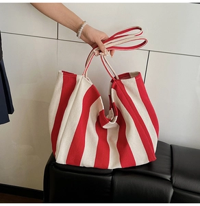 Detail of red and white striped canvas tote bag with long shoulder straps for daily use