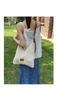 Dettaglio della borsa tote in maglia traforata con cinturini in pelle marrone all'aperto