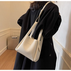 Close-up of white lychee pattern leather bucket bag showing grain texture and detail