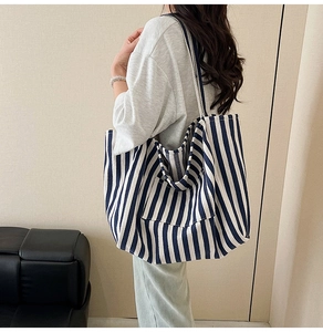 Detail view of large canvas tote bag with navy blue and white vertical stripes