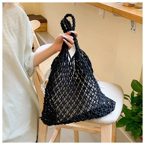 Detail of black woven mesh tote bag featuring a white drawstring inner pouch