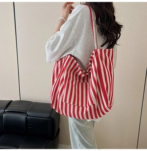 Close-up of a red and white striped canvas tote bag with a functional front pocket