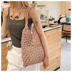 Detail of handwoven hollow-out pink tote bag with thick braided shoulder straps