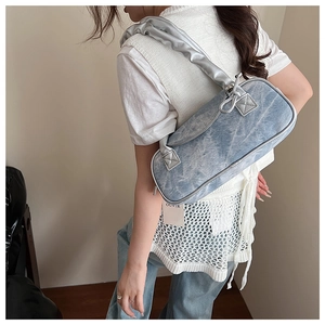 Dettaglio della borsa a cuscino in denim lavato blu con accenti metallici argentati