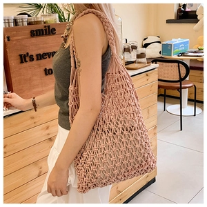 Detailed close-up of pink woven hollow-out mesh pattern on a summer beach tote bag