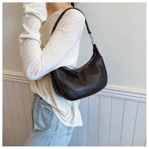 Detail of hobo bag in dark brown wrinkled texture leather with silver metal zipper detail
