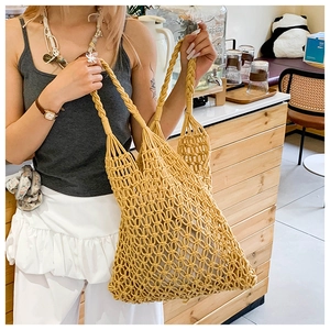Close-up of handmade yellow woven hollow tote bag showing cotton crochet mesh texture