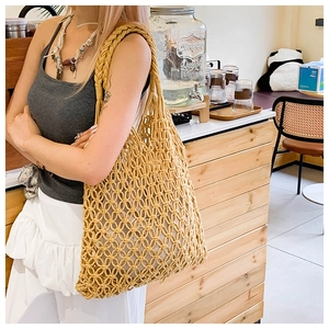 Detail of hand-woven ginger hollow tote bag with thick shoulder strap for summer beach