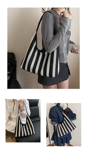 Close-up of black and white vertical striped woven tote bag with shoulder straps