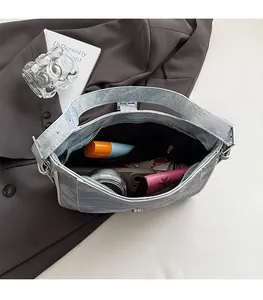 Interior view of light blue denim crescent bag showing spacious compartment and pockets